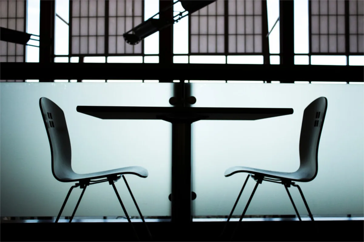 Two chairs facing each other across a table, from the original Cannahire interview-tips article